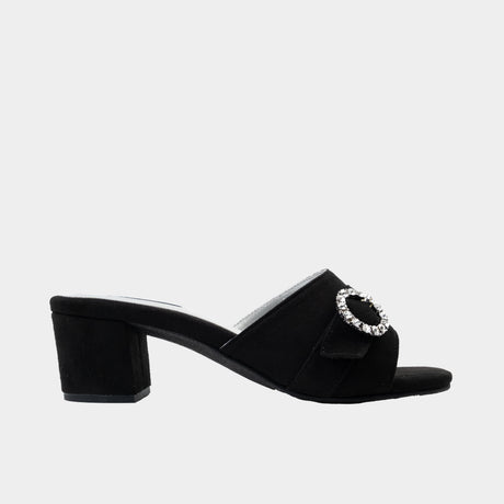 Black suede slide mule with rhinestone circle buckle and low 2-inch block heel.